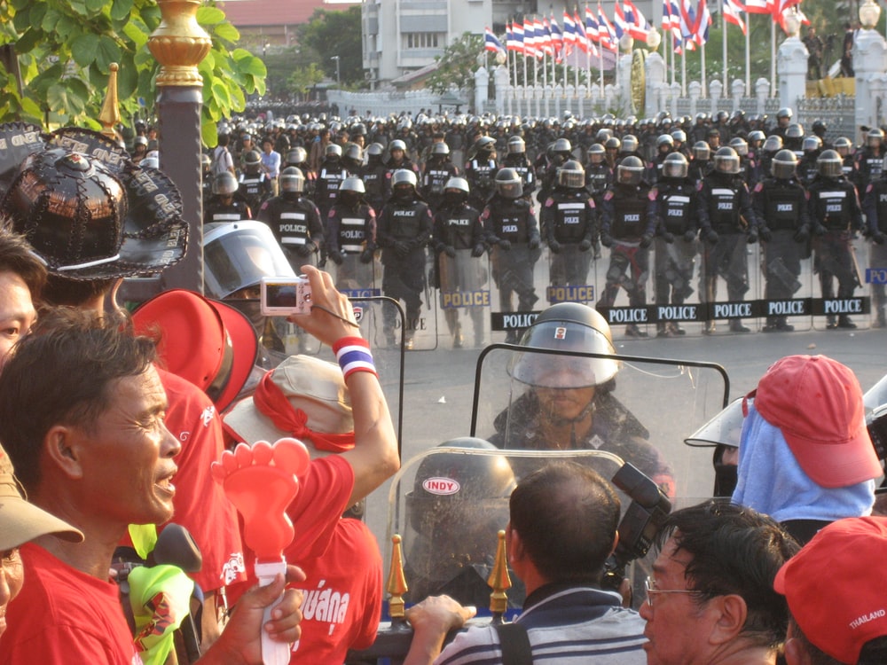 people in red shirts sitting on gray chair during daytime