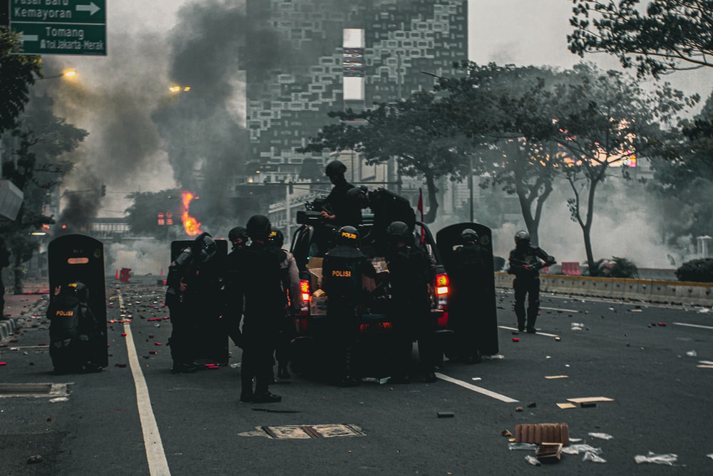 people in black uniform standing on road during daytime