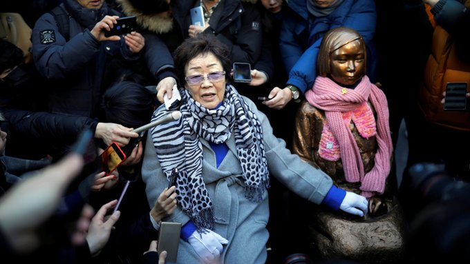 Lee Yong-soo, who was forced to serve in a wartime Japanese brothel, next to a statue symbolizing South Korean “comfort women” in Seoul in 2019.