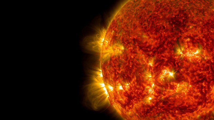 The sun as a fiery red balls spewing particles